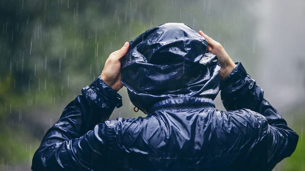 person wearing a rain jacket under the rain